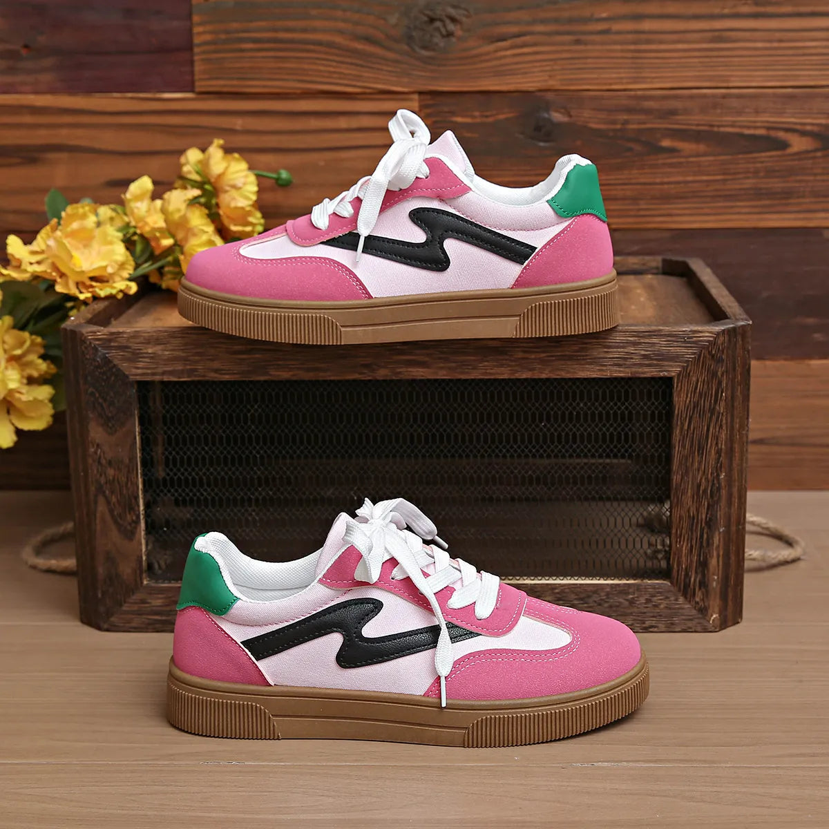 Pink lace-up sneakers with black side stripe and green heel accent