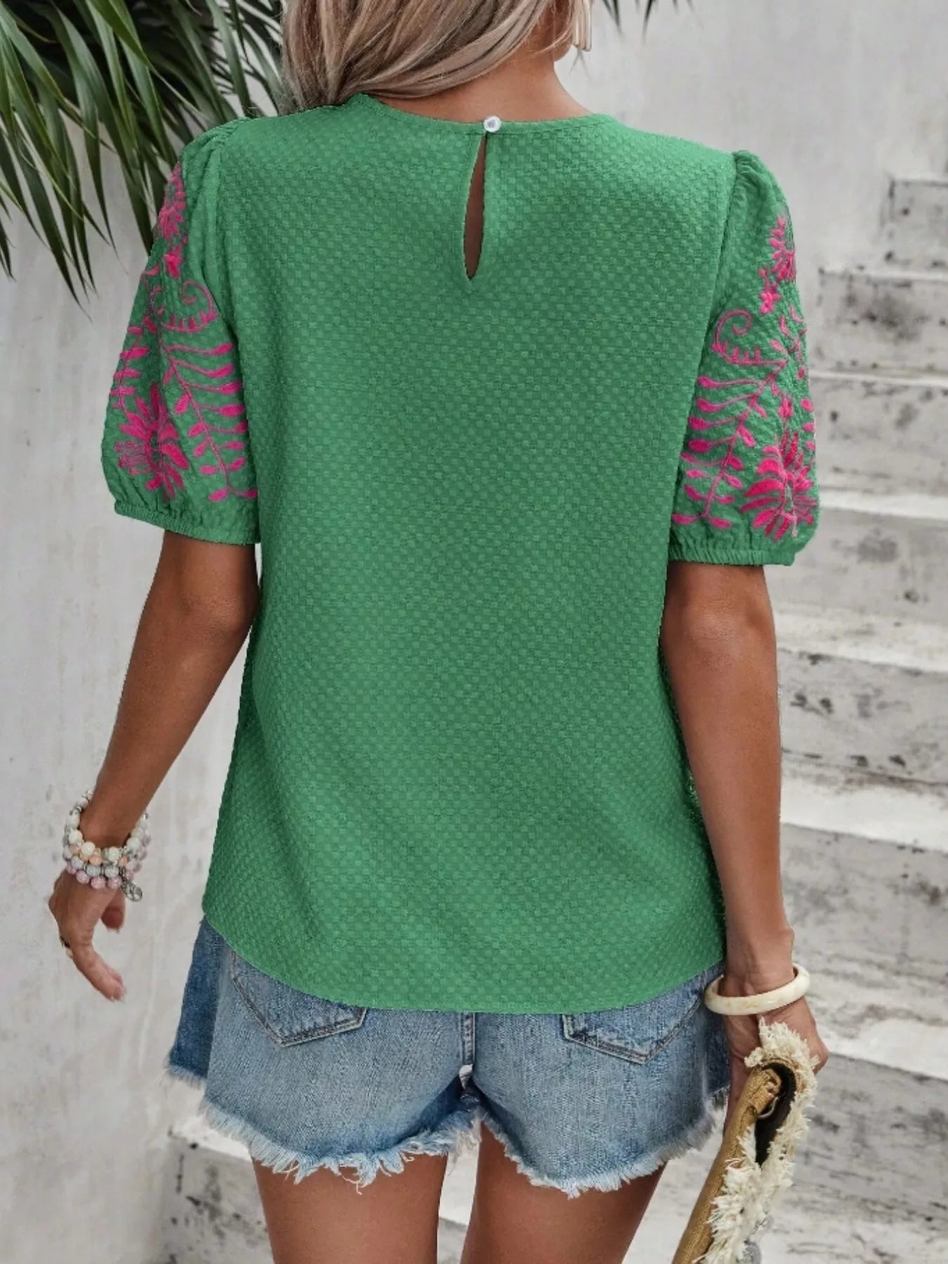 Back view of green embroidered puff sleeve blouse with small keyhole closure