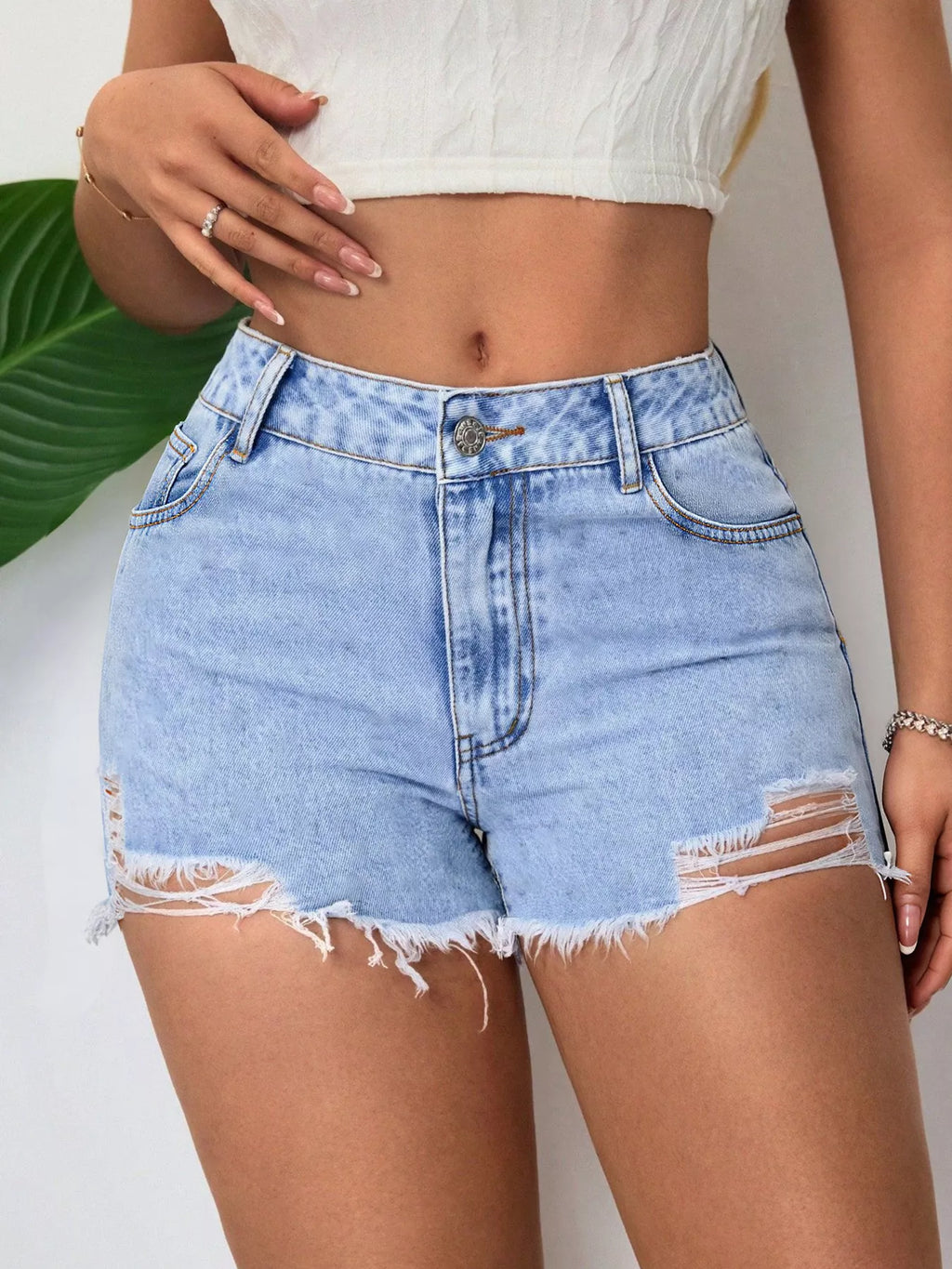 Light blue denim shorts, raw frayed hem and ripped outer leg seams