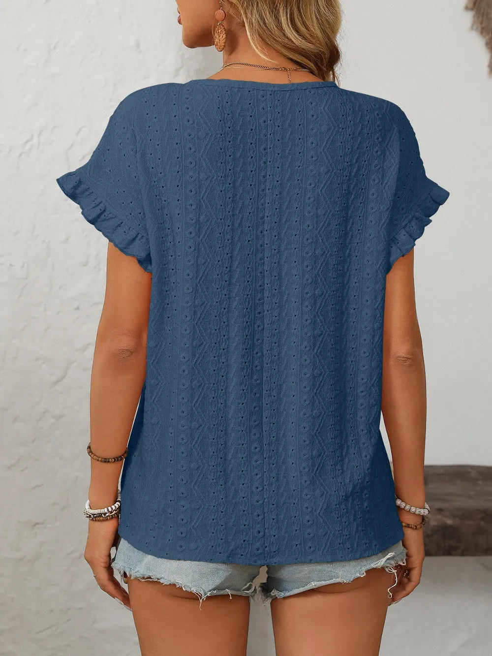 Light blue eyelet round-neck short sleeve top with flutter cuffs, back view.