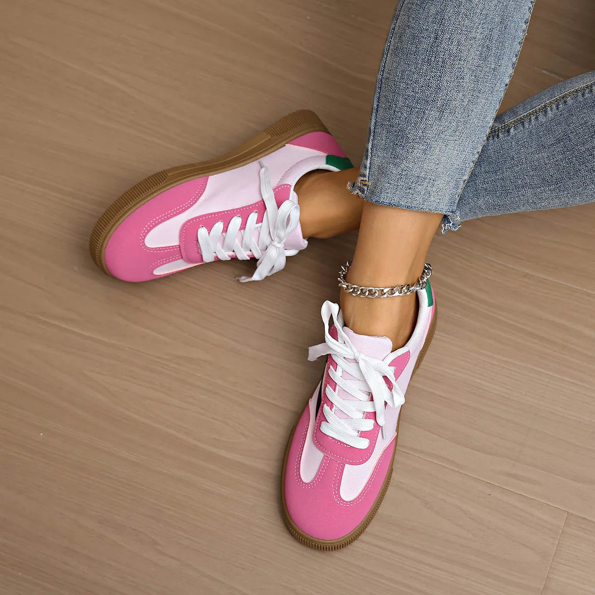 Pink and white lace-up sneakers with white laces and tan rubber sole