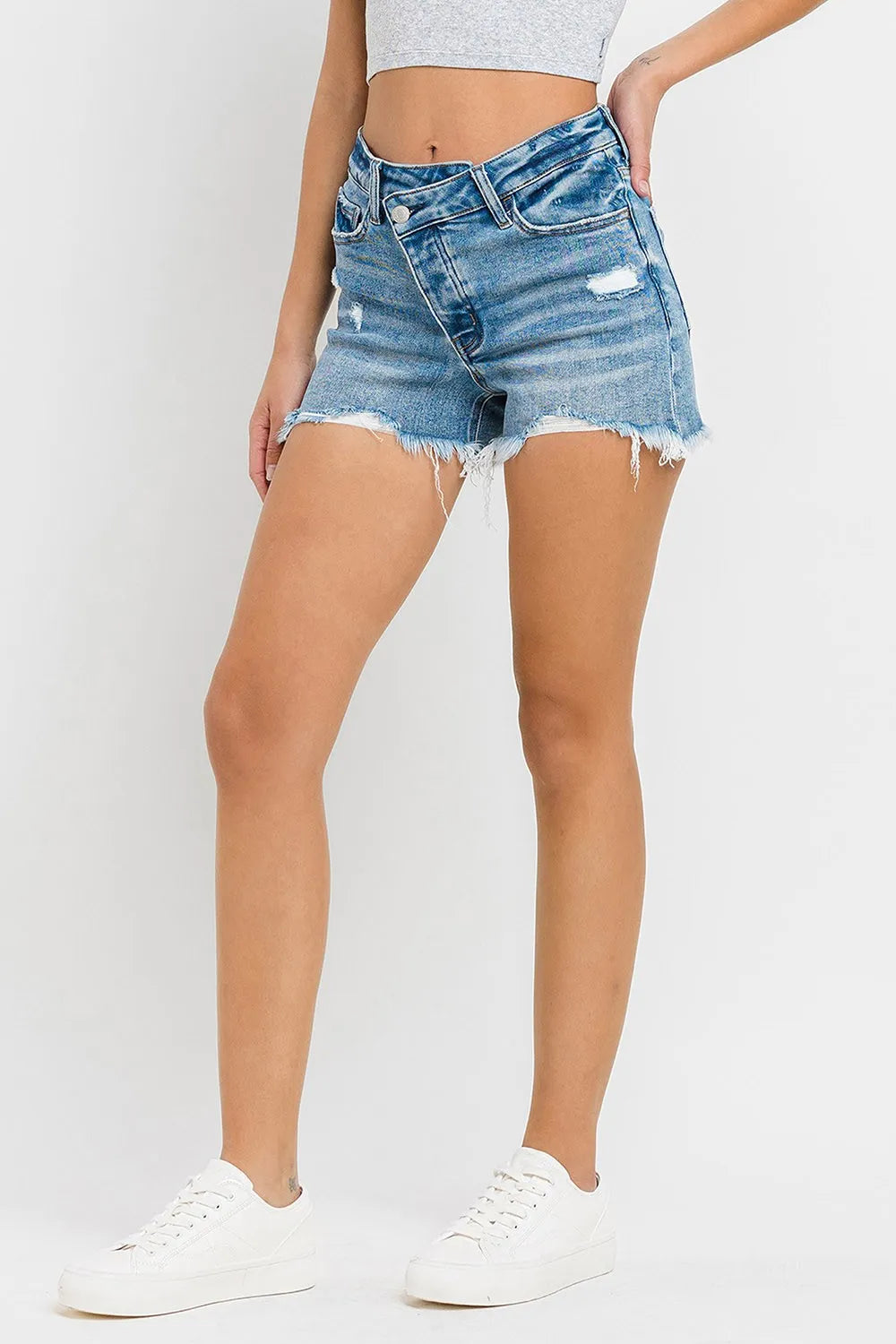 Medium-wash denim shorts with raw frayed hem and stepped waistband, front view