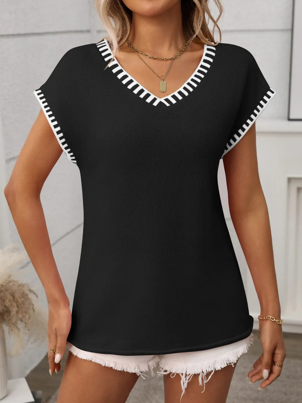Black v-neck knit top with white contrast trim, short sleeves