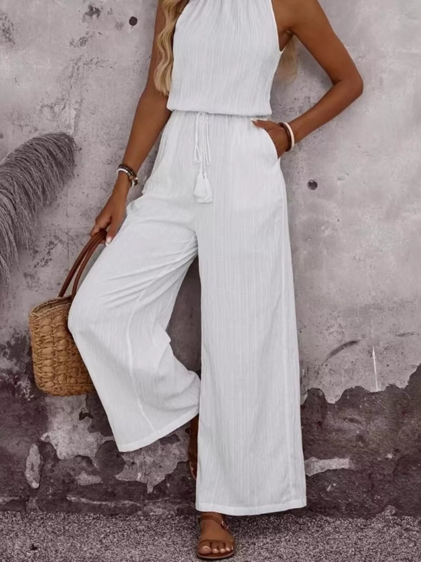 White halter wide-leg jumpsuit with tassel waist tie and flowy wide legs