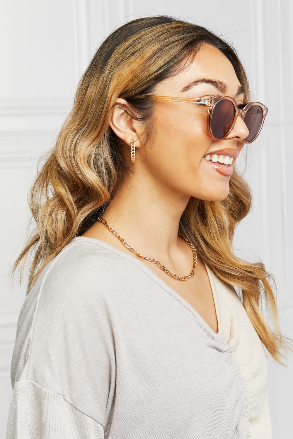 Tan round sunglasses on face, brown lenses and gold-tone full rim