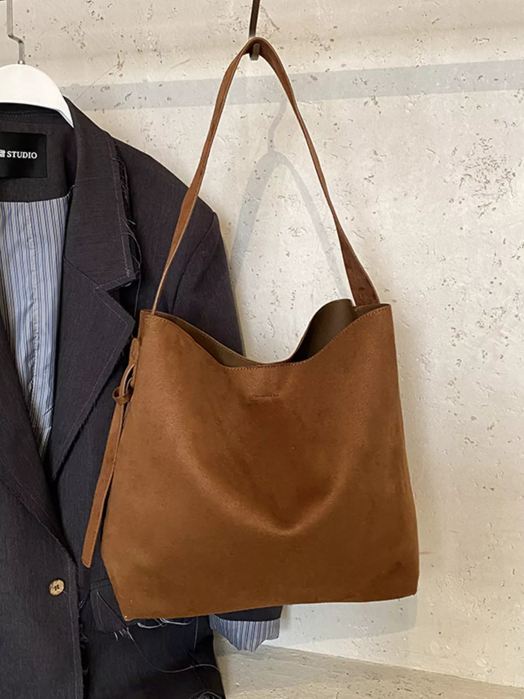 Brown suede-style tote bag with adjustable shoulder strap and open top