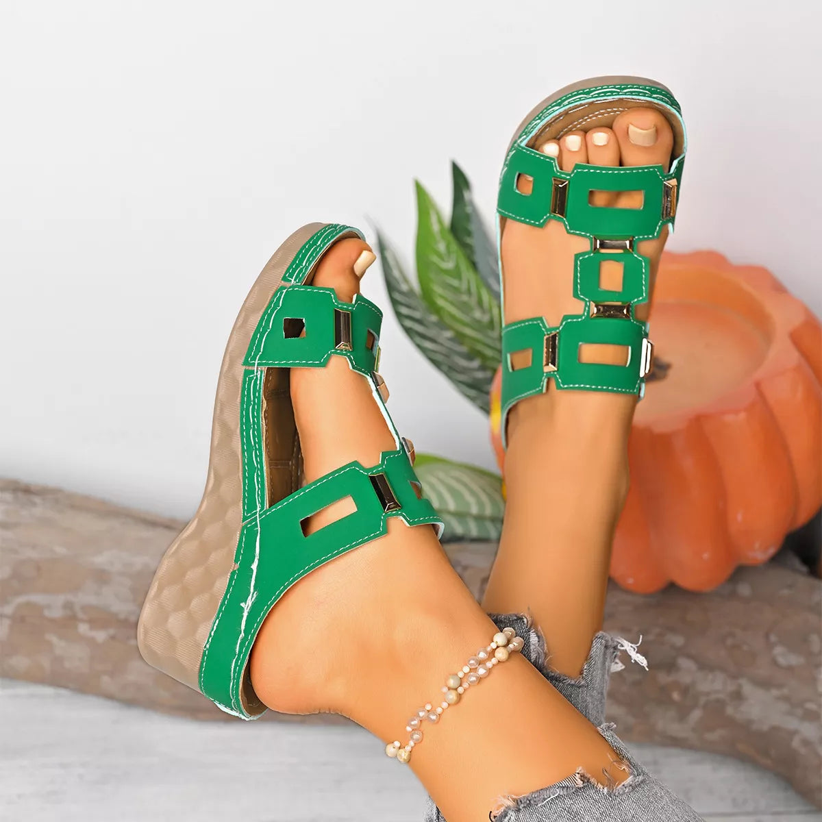 Green open-toe wedge sandal with stacked square cutout straps and buckle detail.