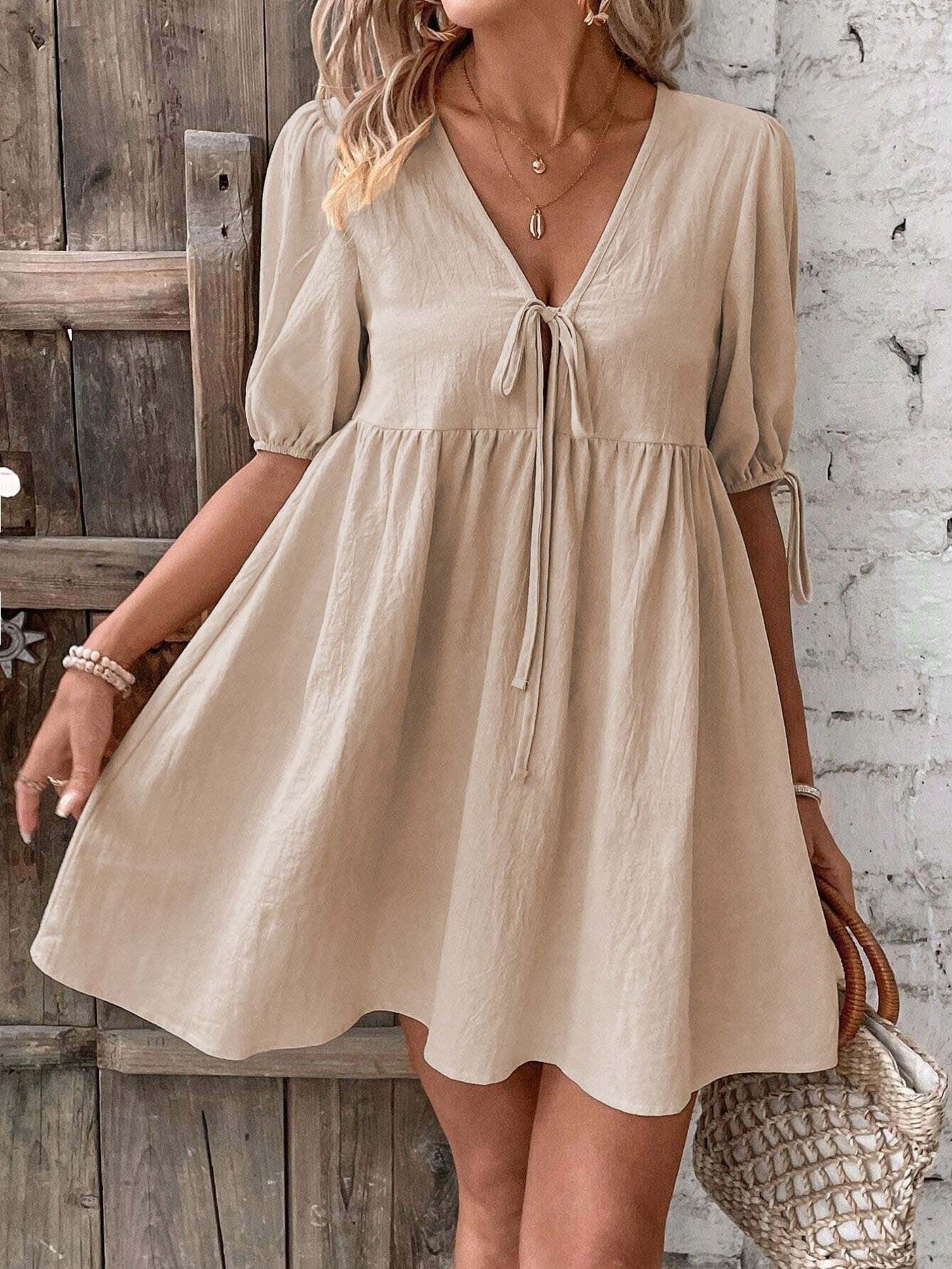 Cream/khaki tie-front mini dress with V-neck, puff sleeves, and adjustable strings