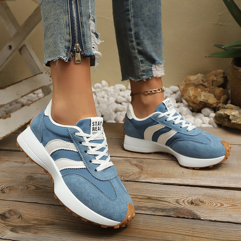 Sky blue lace-up sneakers with round toe, white stripes, and textured rubber sole