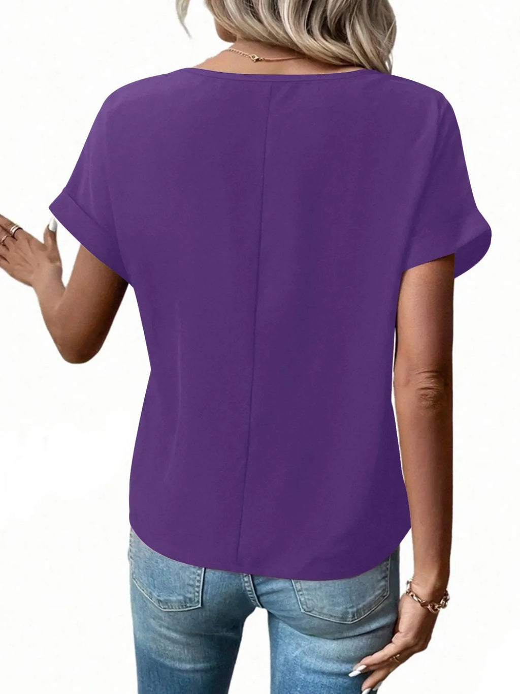 Back view of purple short-sleeve zip blouse with curved drape hem