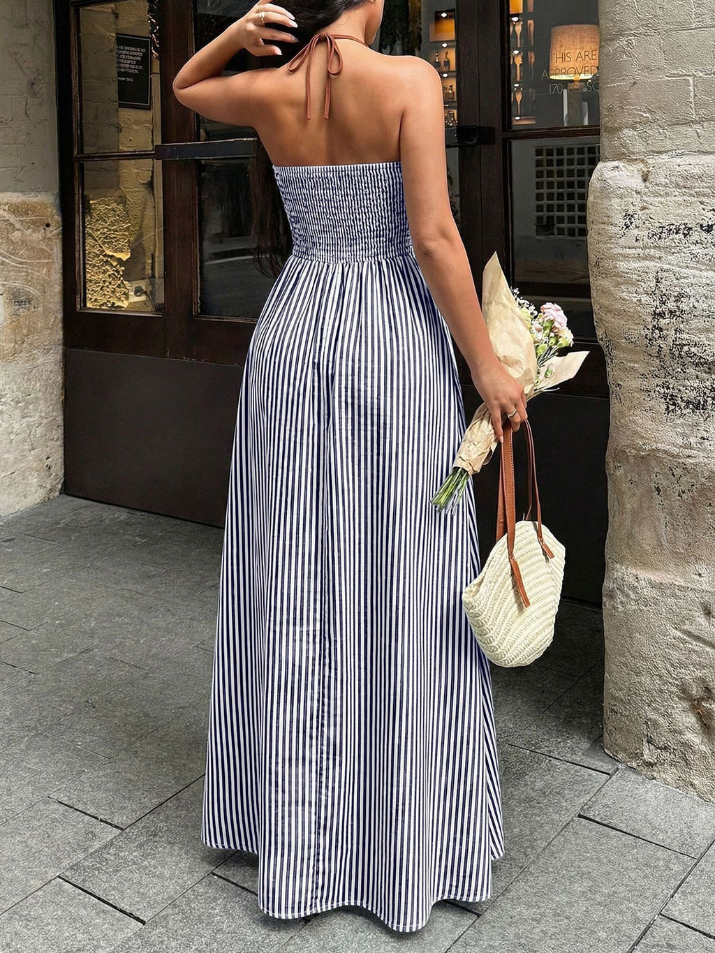 Back view of navy and white striped halter maxi dress with smocked back waistband