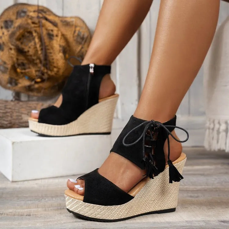Black peep-toe wedge sandals with ankle lace-up, tassels, and woven-texture platform