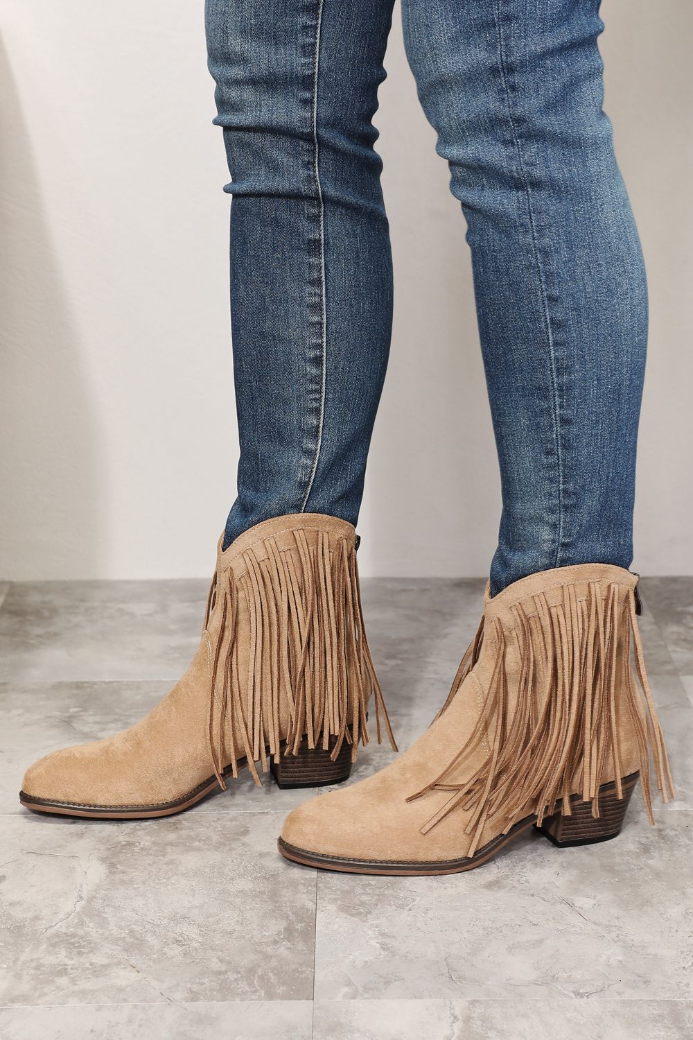 Khaki suede fringe cowboy ankle boots, back view with stacked heel