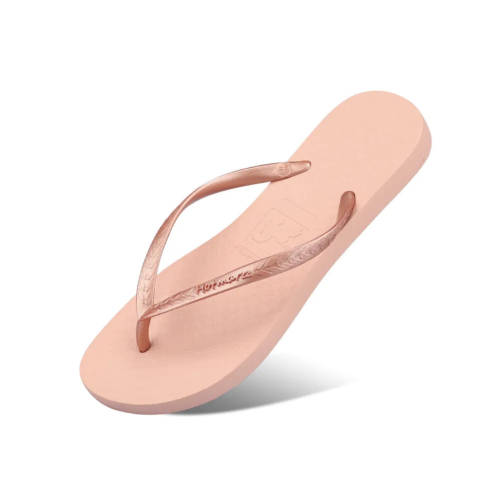 Light pink toe-post flat sandal pair, textured footbed and curved thong strap