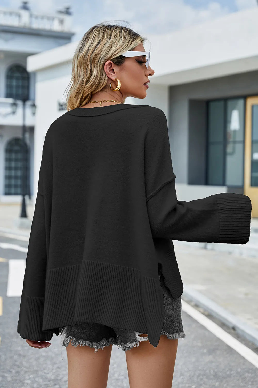 Black sweater back view with long sleeves; ribbed hem and high-low split sides