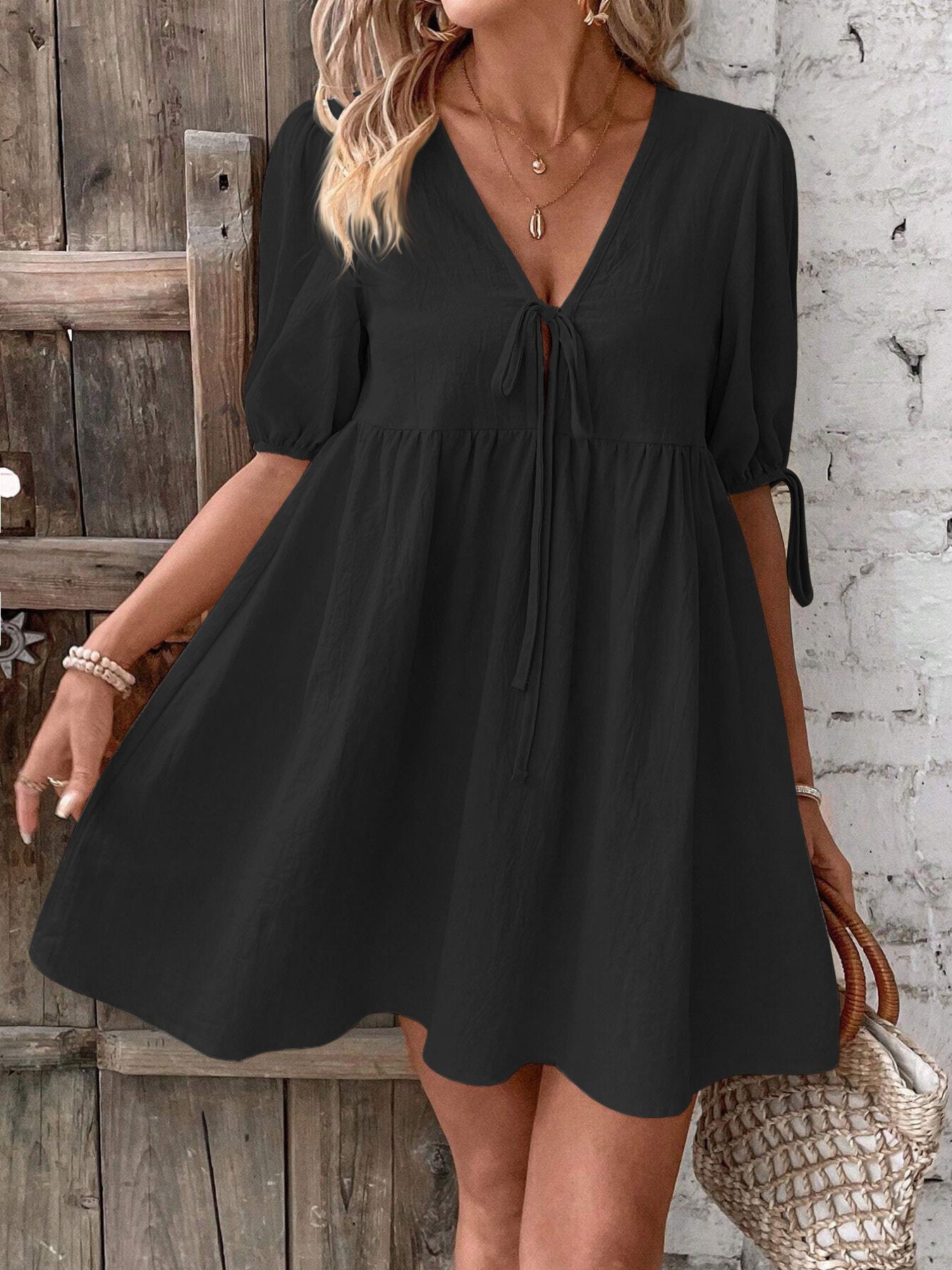 Black puff-sleeve mini dress with tie neckline and gathered waist