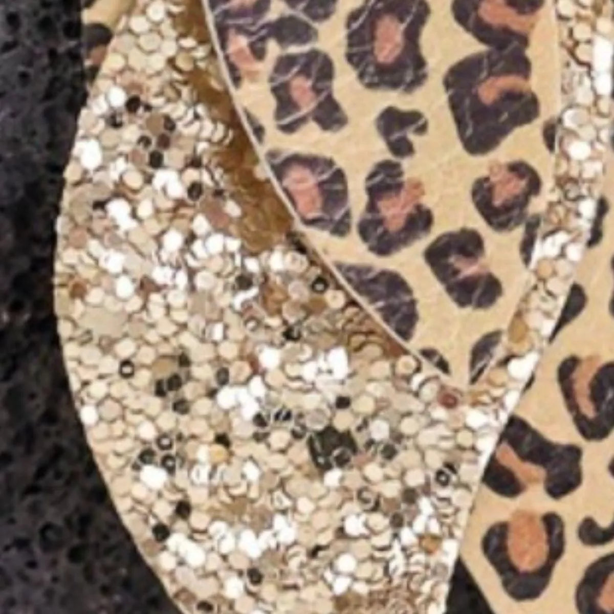 Close-up of gold leopard print and gold glitter leaf drop earrings