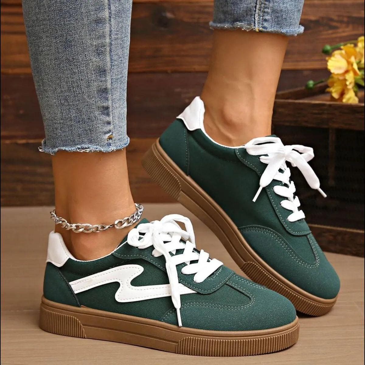 Dark green lace-up sneakers with white eyelets and tan rubber sole