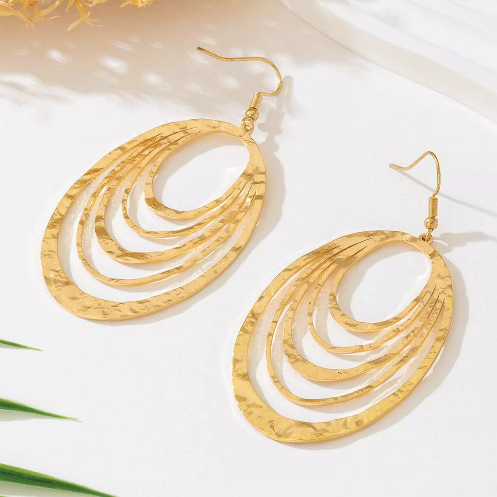 Gold-plated oval layered hoop earrings featuring concentric curved bands and hooks