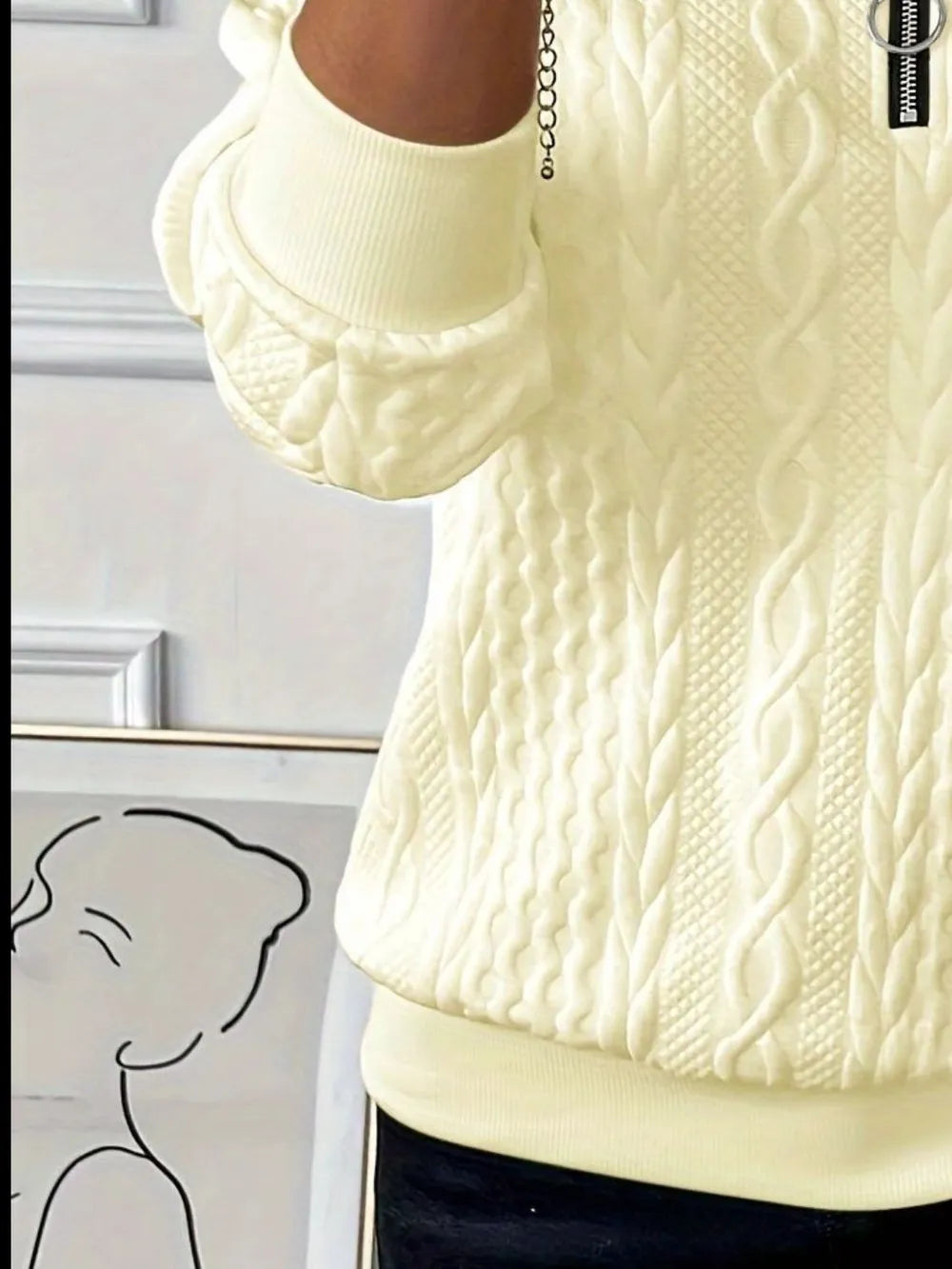 Cream textured long-sleeve half-zip sweatshirt detail at collar and ribbed hem