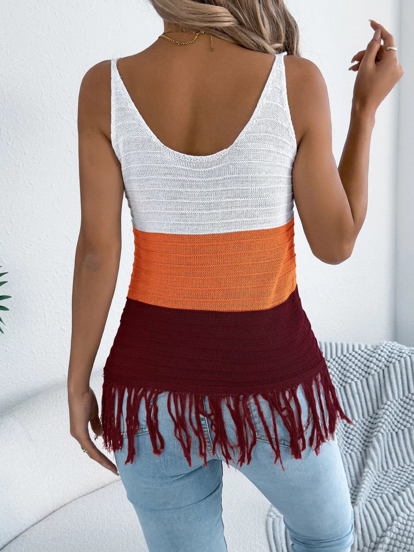 Back of color block knit cami with V-back, white, orange, and dark red fringe hem