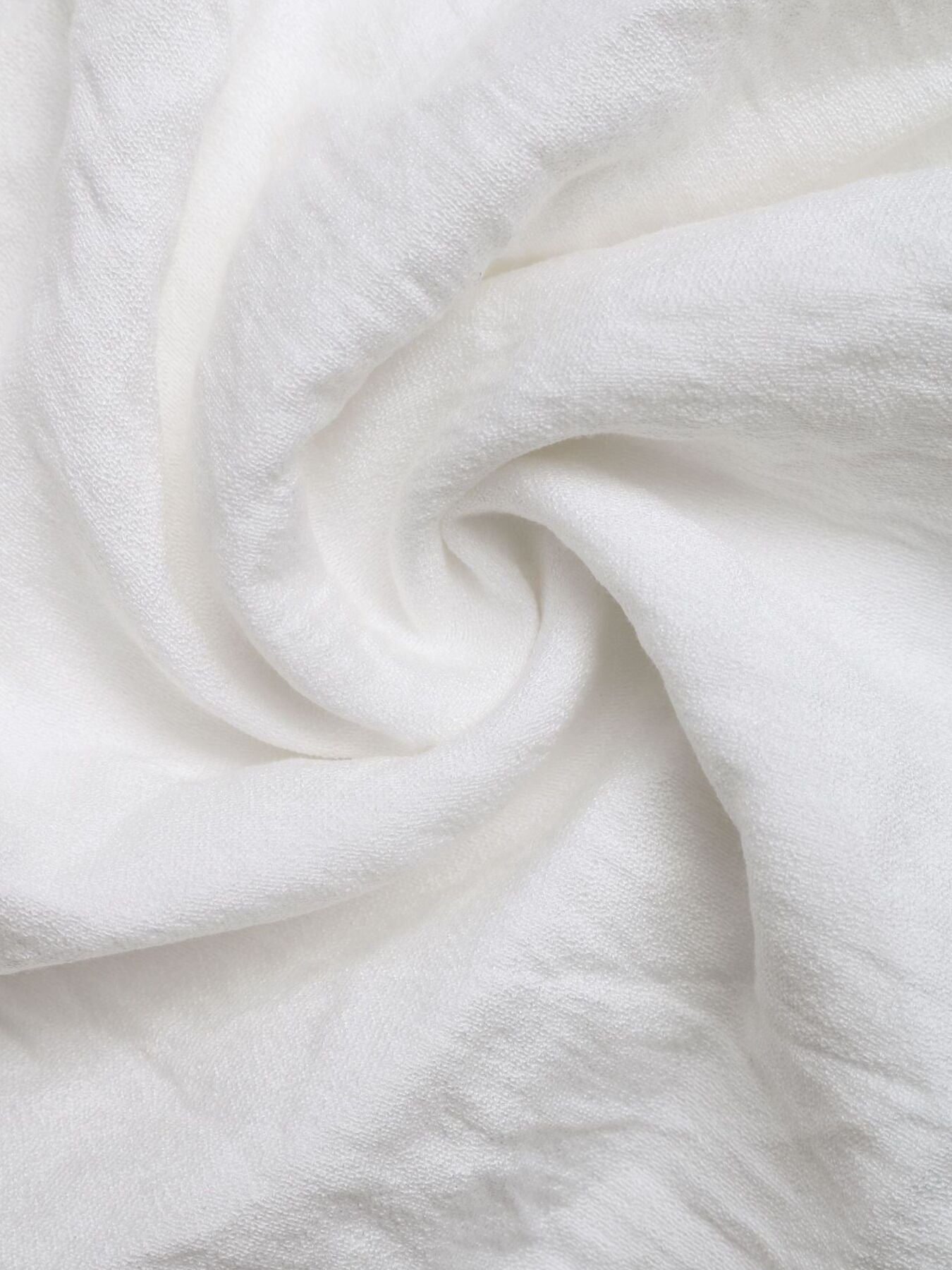 Ivory shorts fabric close-up with soft textured weave and draped folds