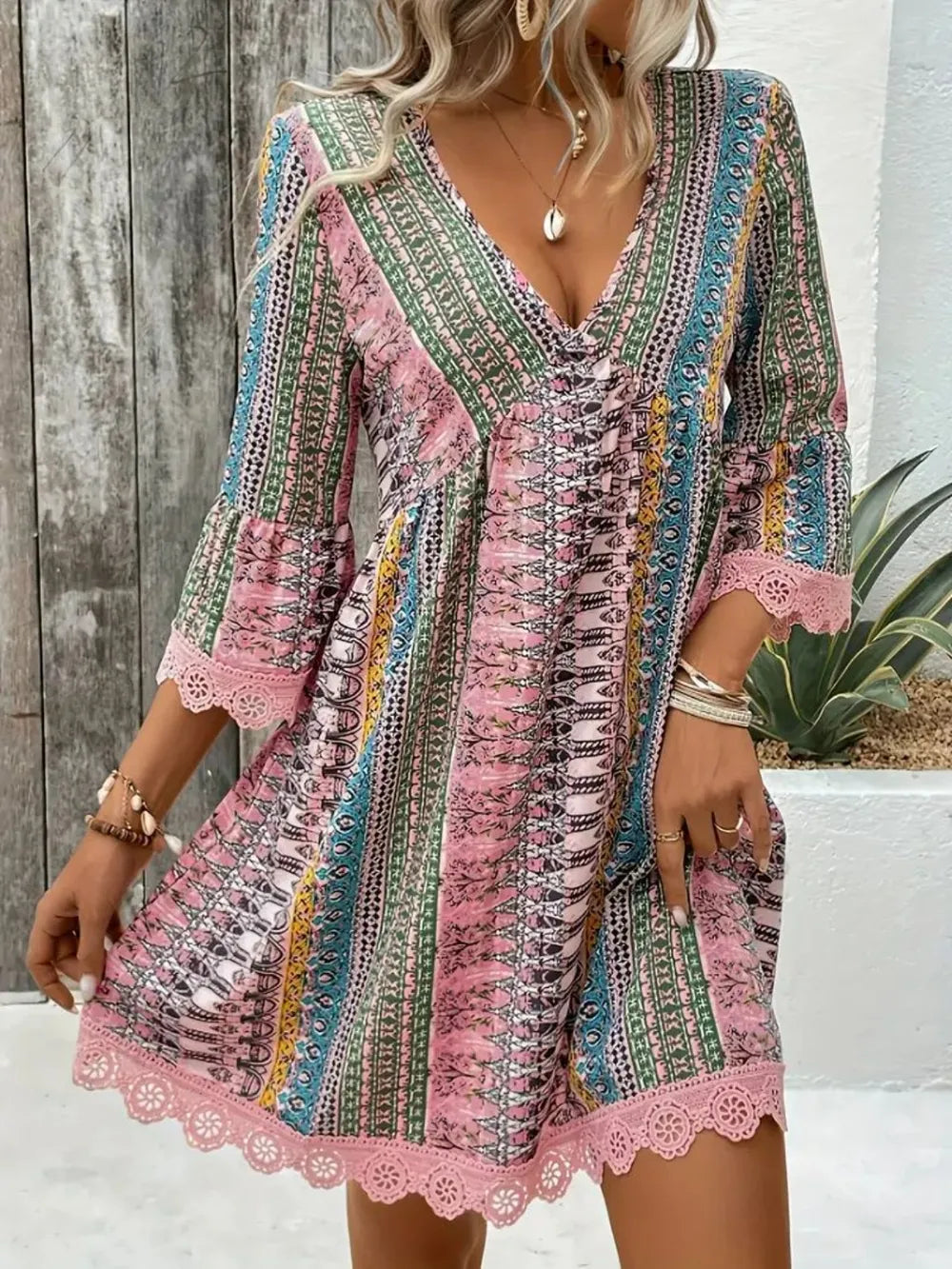 Blush pink printed V-neck dress with lace hem, 3/4 sleeves, and crisscross bodice