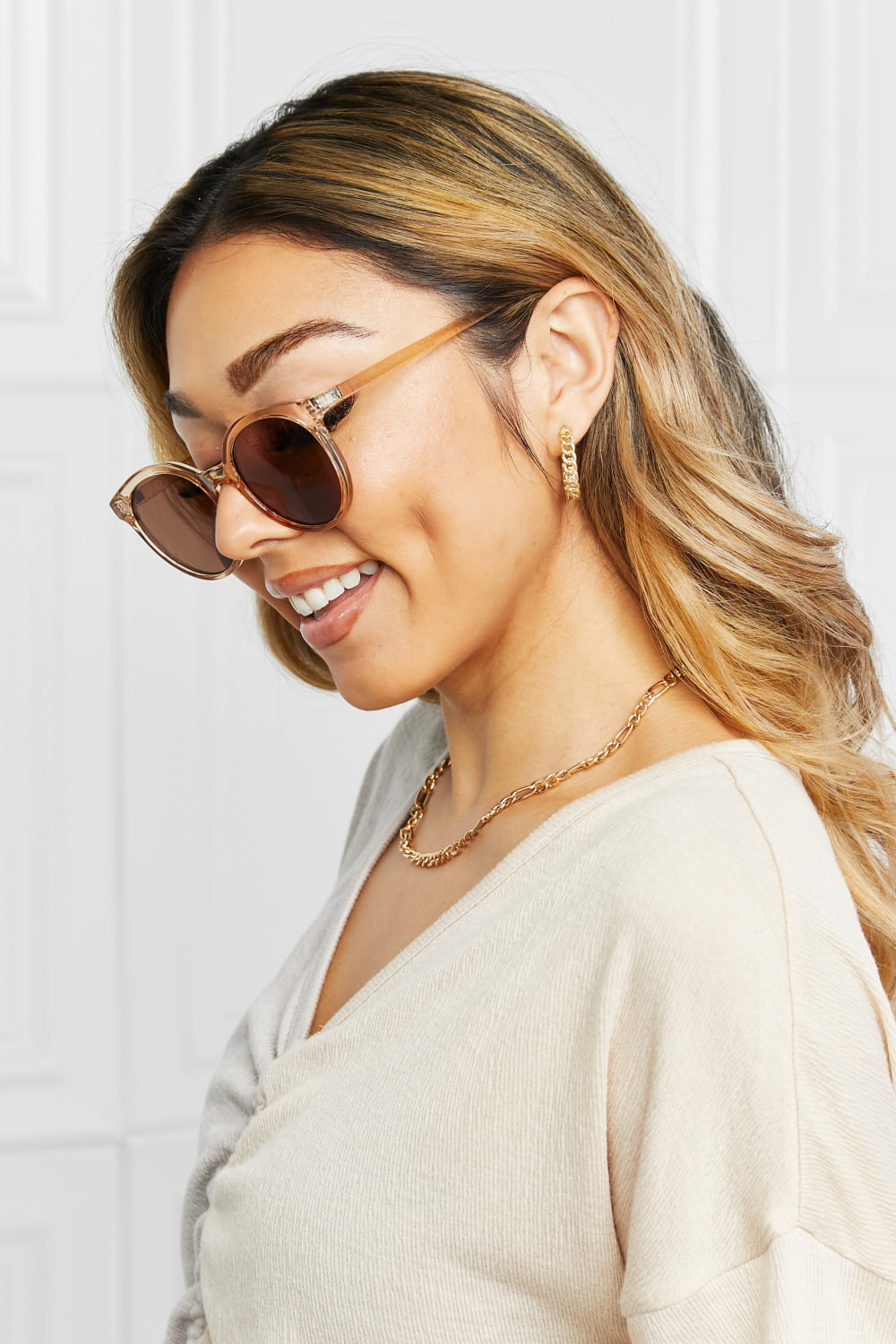 Side view: tan round sunglasses with brown lenses and gold-tone temples