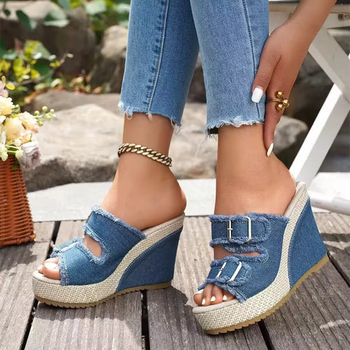 Blue denim wedge sandals with open toe, ankle strap, and two buckles