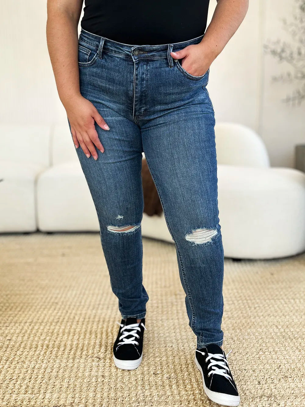 Dark blue mid-waist slim jeans front with ripped knee, light fade, and straight skinny leg