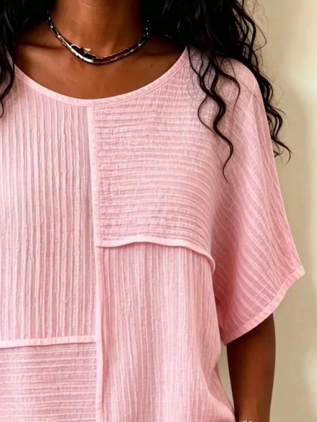 Pink textured round-neck half-sleeve blouse close-up of vertical seam and yoke