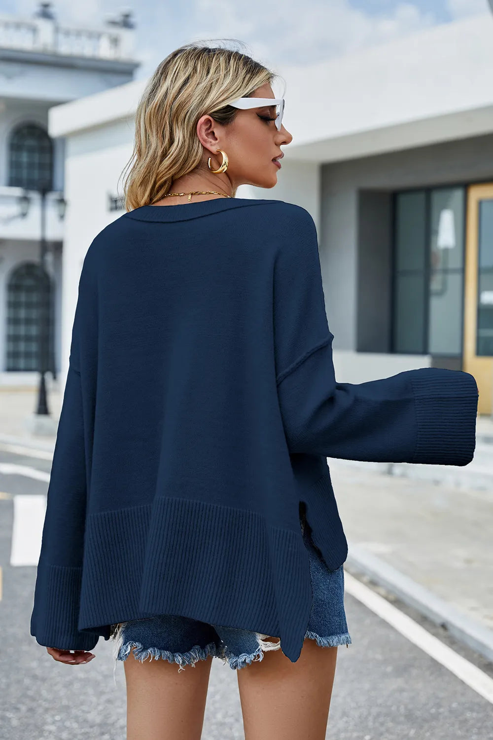 Back view: high-low slit sweater in navy, long sleeves and ribbed hemline