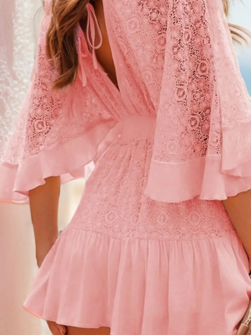 Blush pink lace mini dress close-up of ruffle hem and tiered skirt