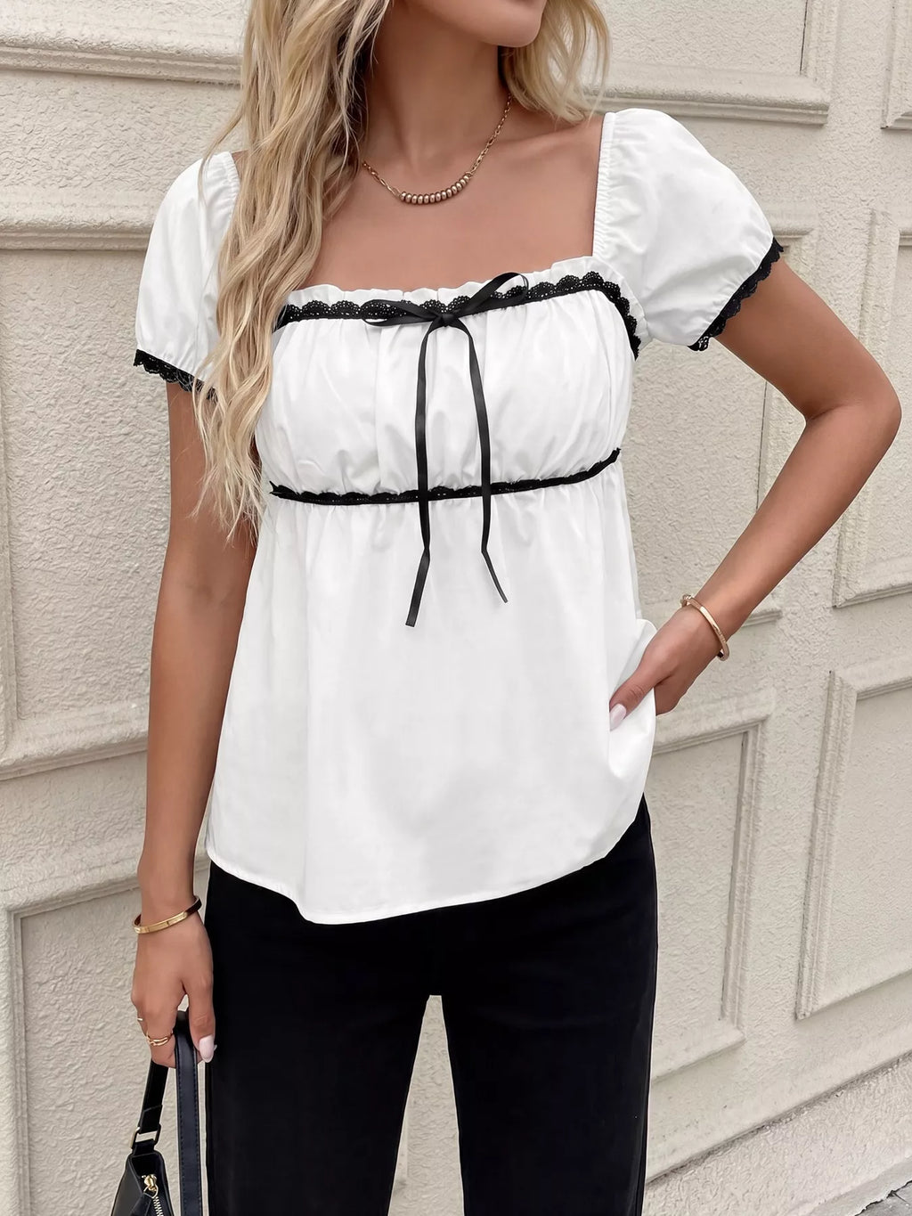 White lace-trim short sleeve blouse with black ribbon bow and vertical tie detail