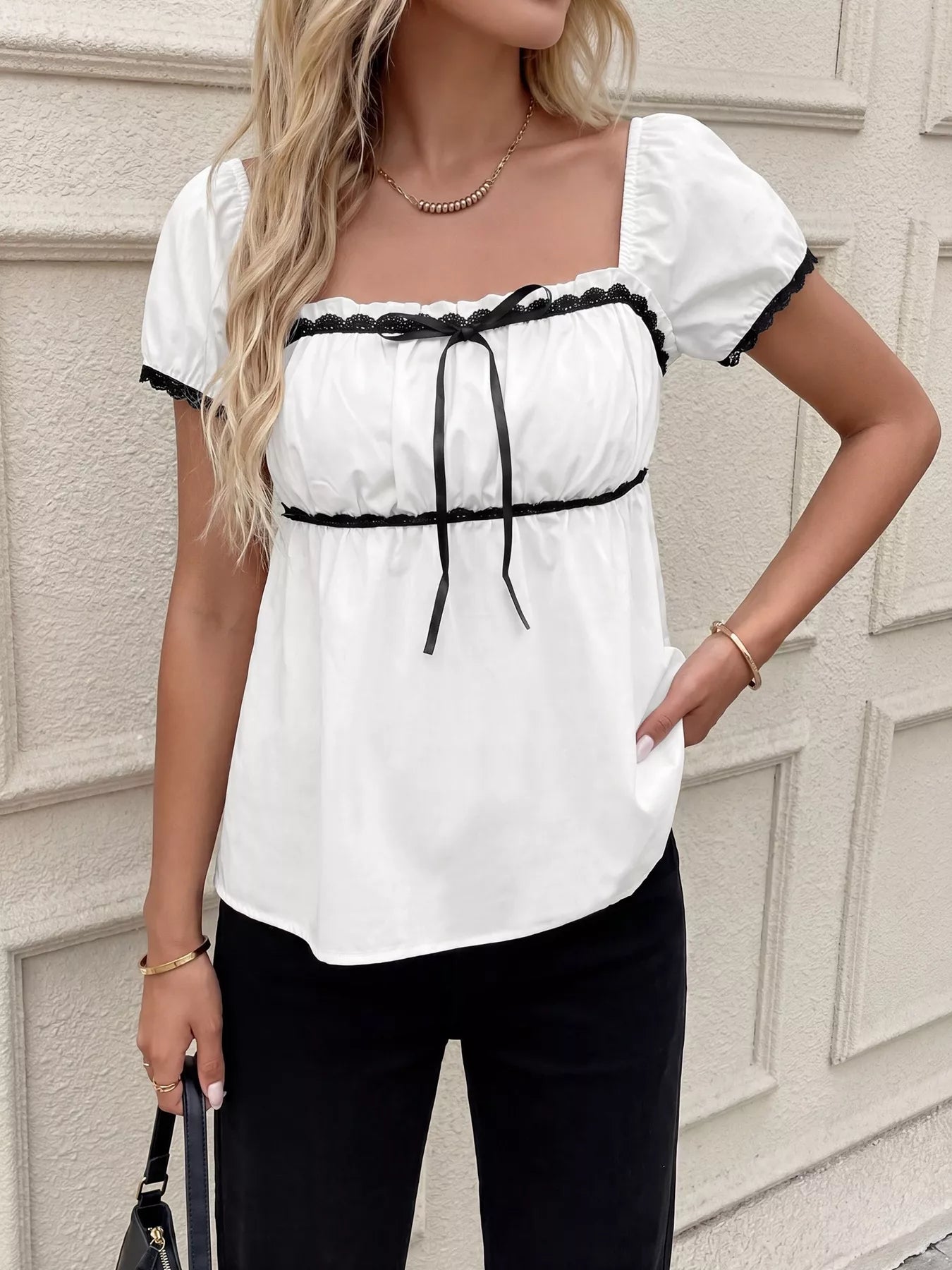 White lace-trim short sleeve blouse with black ribbon bow and vertical tie detail