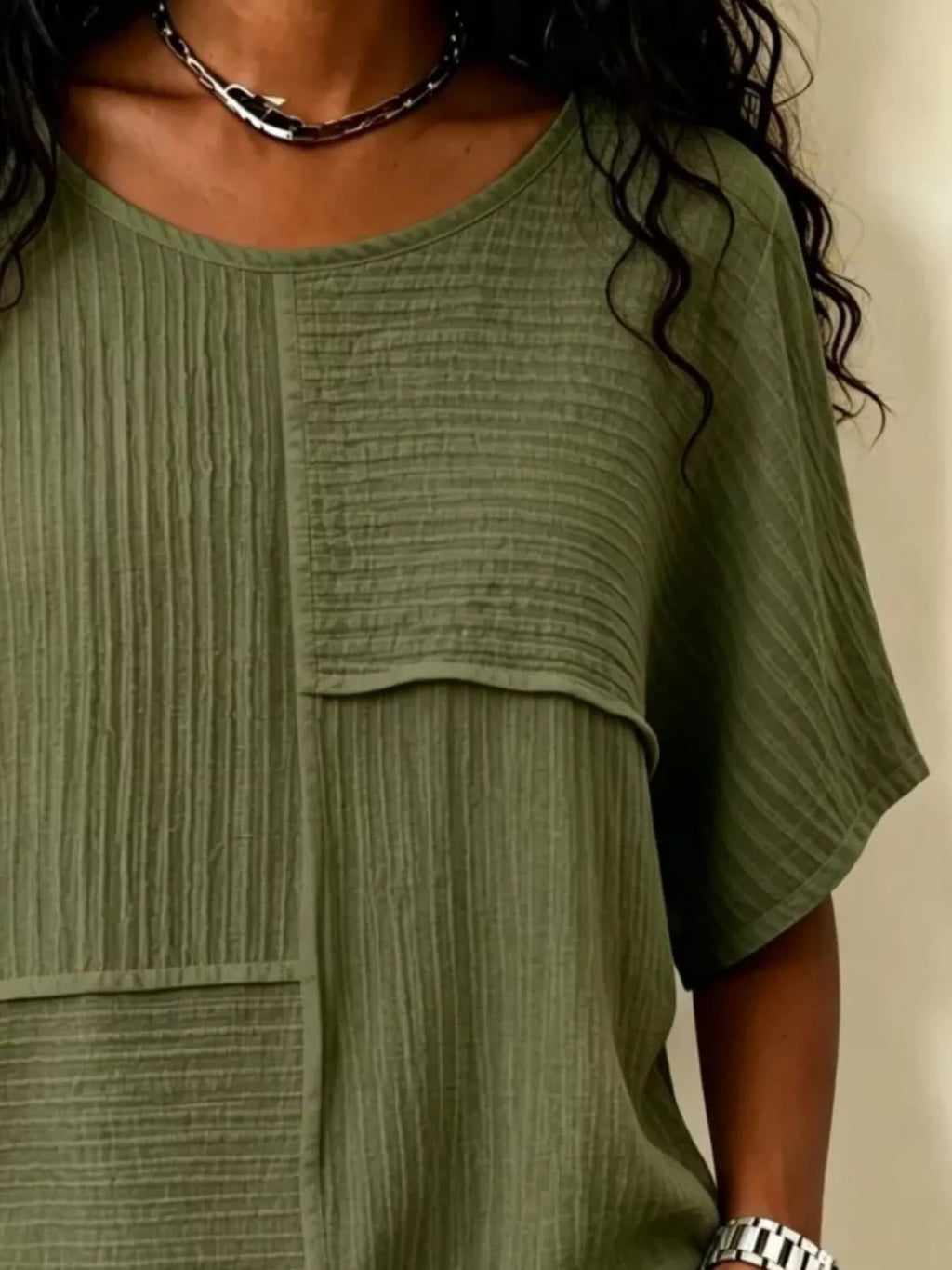 Textured olive green round-neck half-sleeve blouse with vertical rib pattern and pocket panel