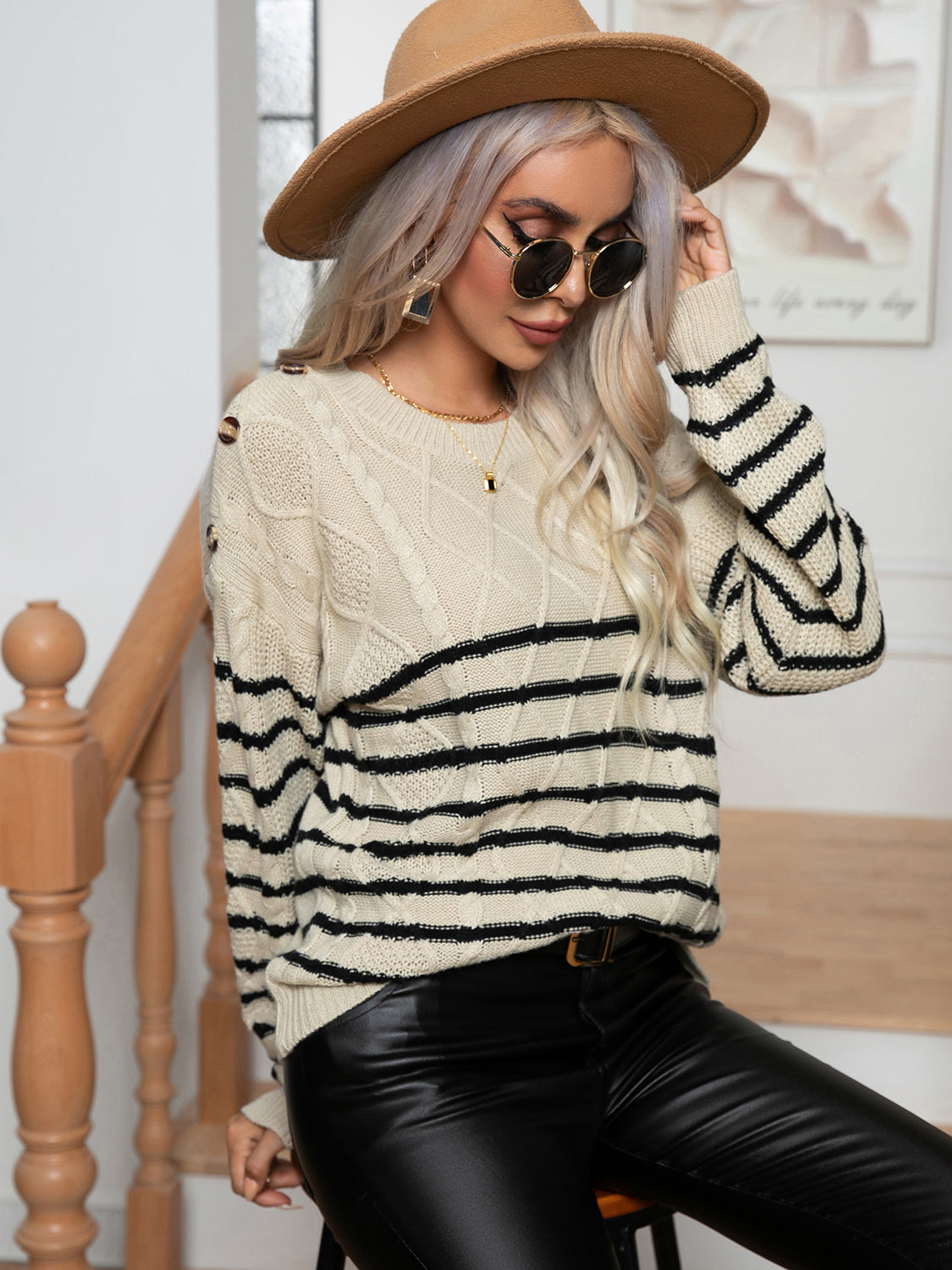 Cream/ivory cable-knit sweater with round neck and black horizontal stripe pattern