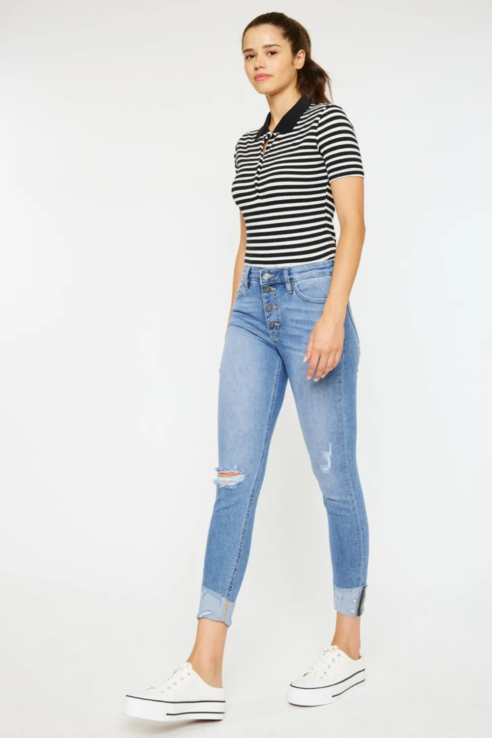 Light wash button-fly jeans with whisker distressing at thighs and ankle cuff rips