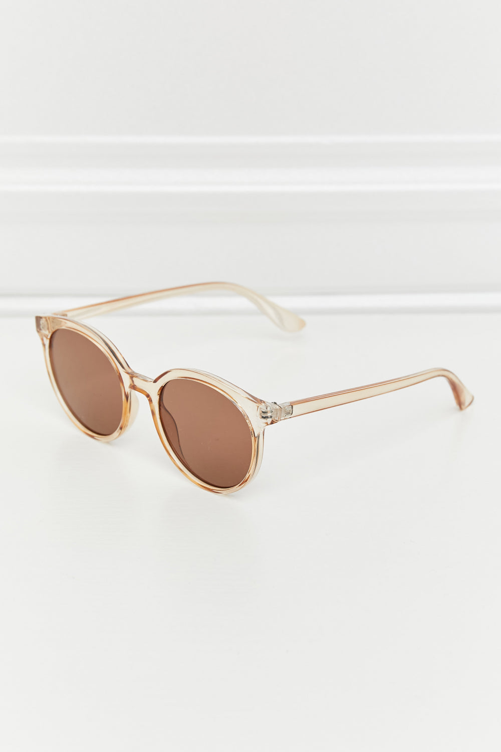 Tan round sunglasses side profile with clear-to-tan temples and brown lenses
