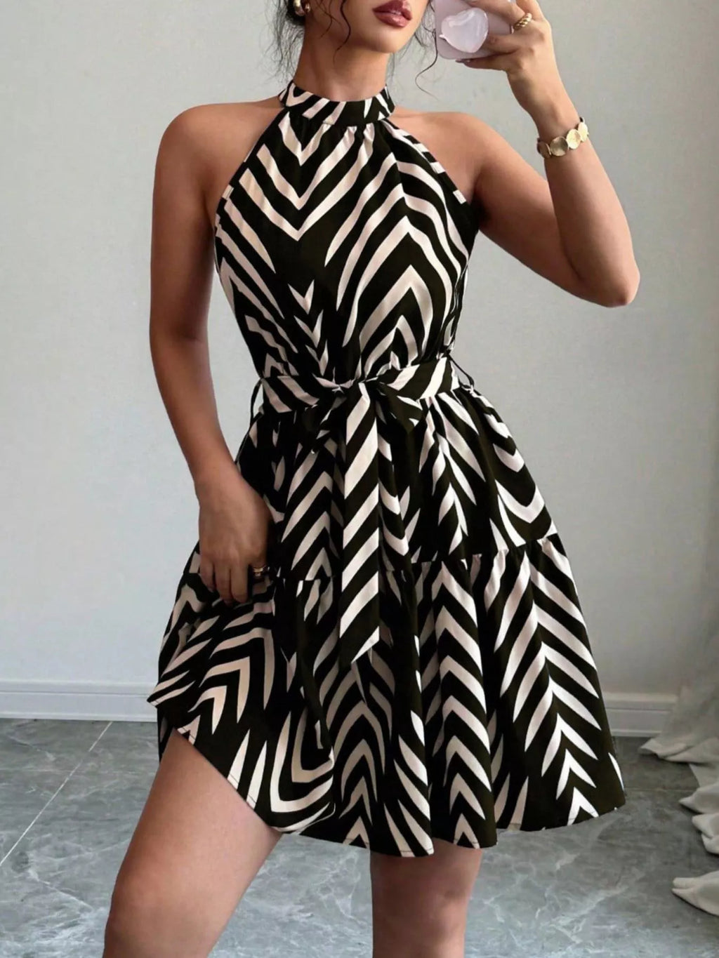 Black zebra-print halter dress with tie waist, fitted bodice and ruffled skirt hem