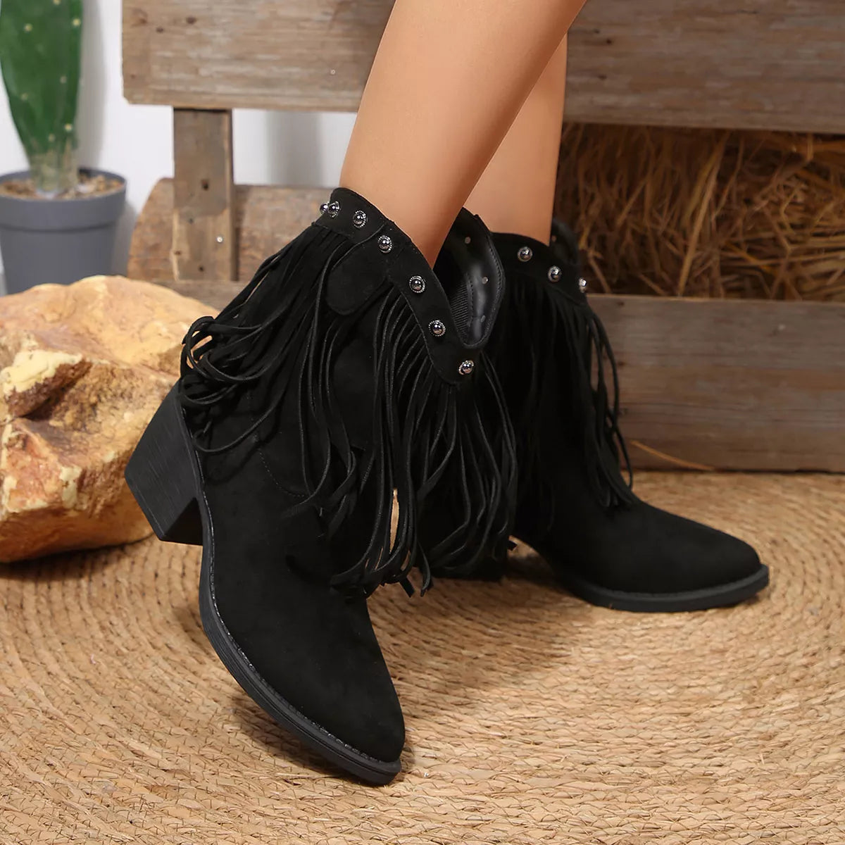 Black suede ankle boots with fringe, studded collar, and block heel